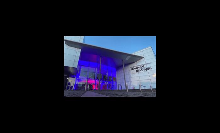 The theatre building lit up with blue and pink lights.